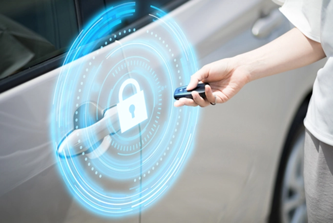 An arm holding a key next to a car door with a projection of a padlock