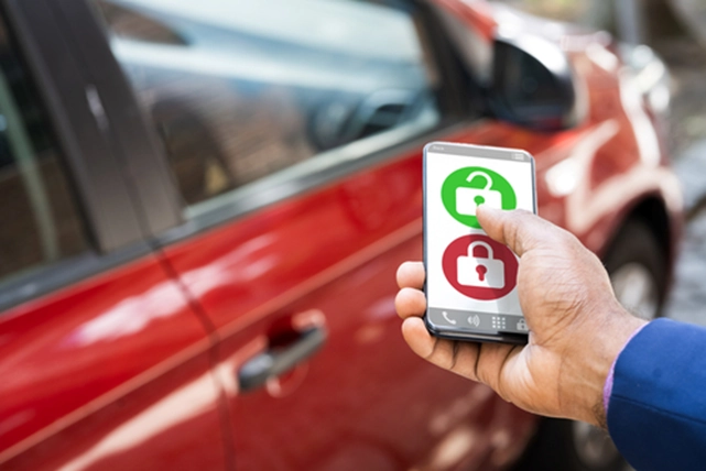 a hand pressing on a app to unlock a car